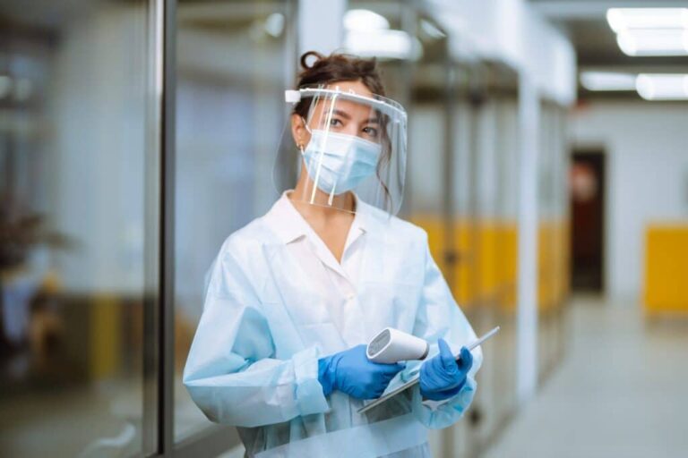 Healthcare worker checking a temperature with protective equipment